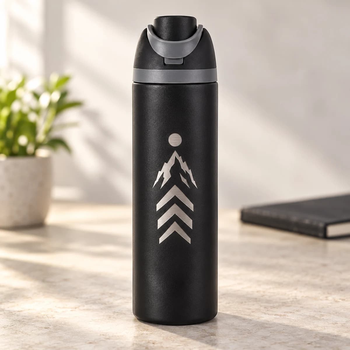 Black 24 oz stainless steel sports bottle with an original metallic mountain laser engraving